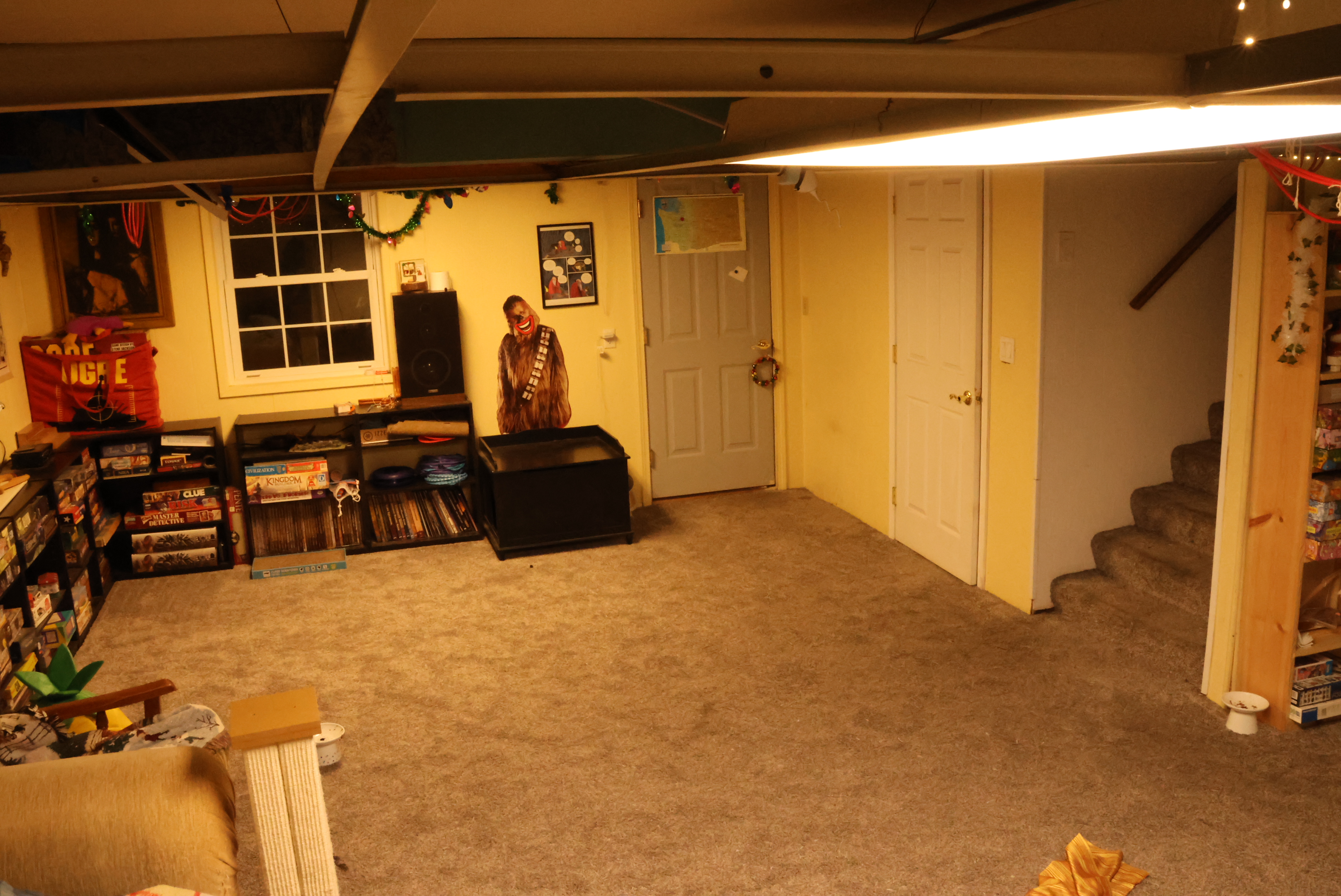 The basement in 2023. Much tidier! There's a new bookshelf I built over against the wall, and the ceiling tiles have all been removed. Since they've been gone Morrie has had way fewer asthma issues when she's down there.