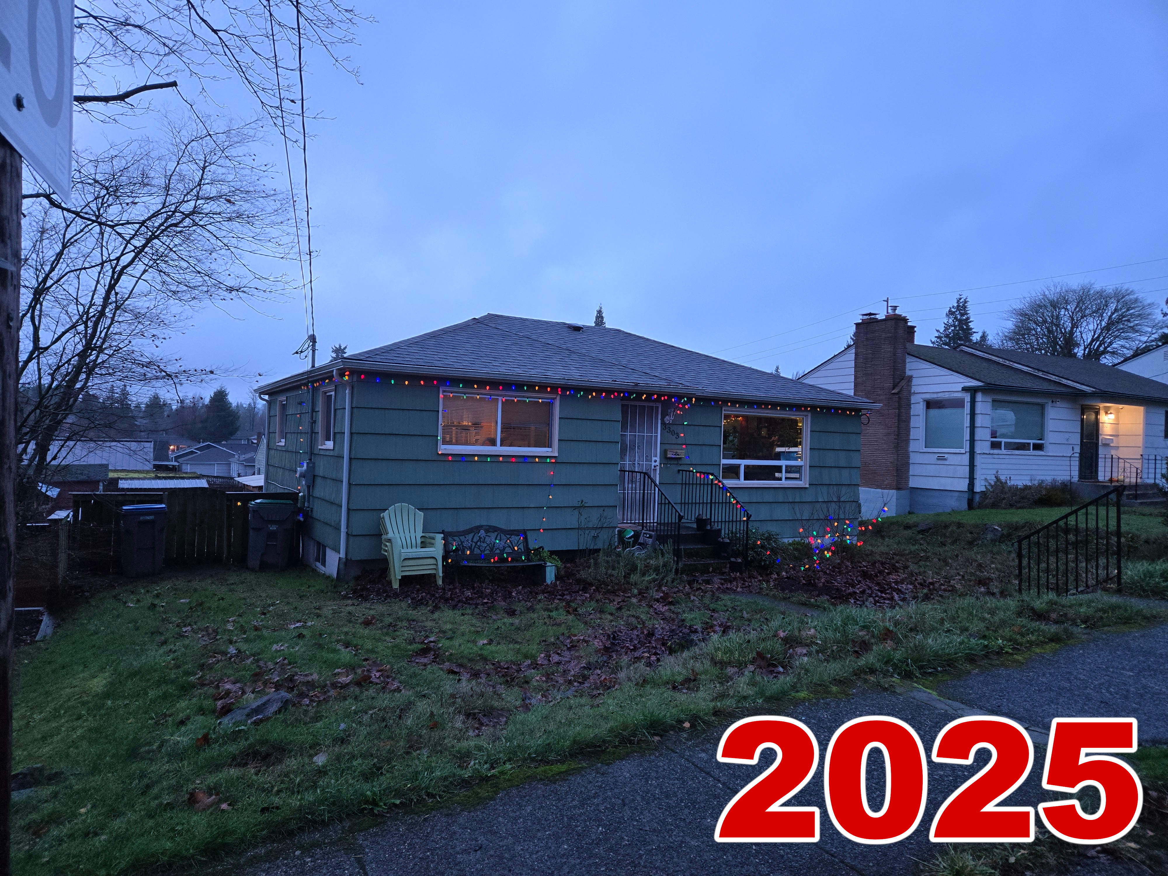 Exterior, taken shortly before sunset. Outdoor deco scaled back, same as inside, but I think the lights look nice. The vine maples are finally big enough to support some lights on them. 